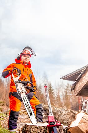 A man cutting a tree with a chain saw